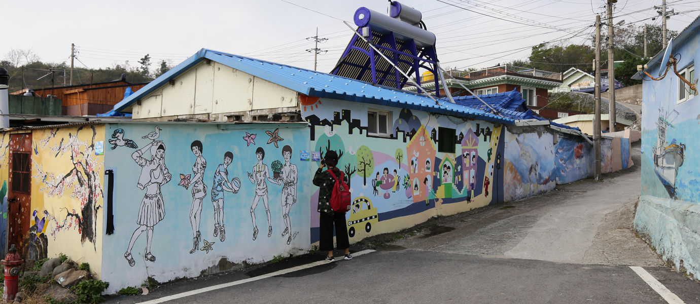 읍천항 벽화마을 벽화그림을 보고 있는 여자 관광객