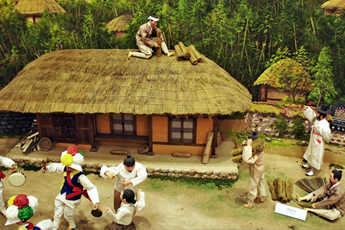 옛날 양동마을을 모형으로 만든 전시품(사람들이 풍물놀이를하고 초가집을 보수하는 모습)