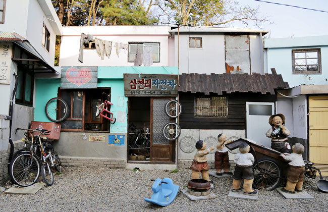 옛날 모습을 재현해놓은 사진 _ 가게(산천리 자전차) 앞에서 고물장수와 아이들의 모형