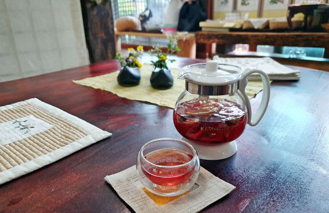 붉은 꽃차가 담긴 주전자와 잔