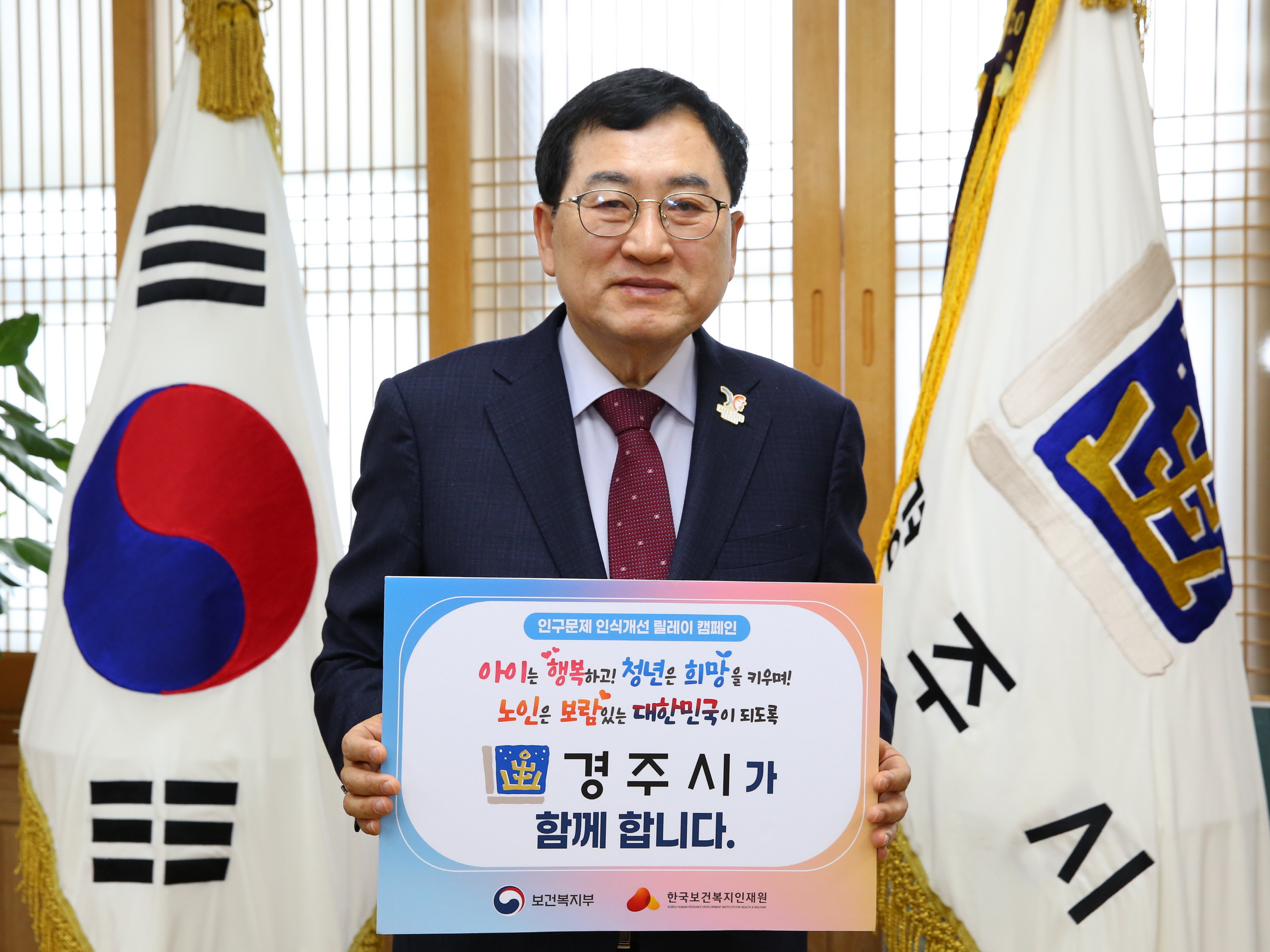 주낙영 경주시장이 17일 오전 청사 집무실에서 ‘인구문제 인식개선 릴레이 캠페인’에 동참하며 캠페인 메시지가 담긴 피켓을 들고 기념촬영을 하고 있다.