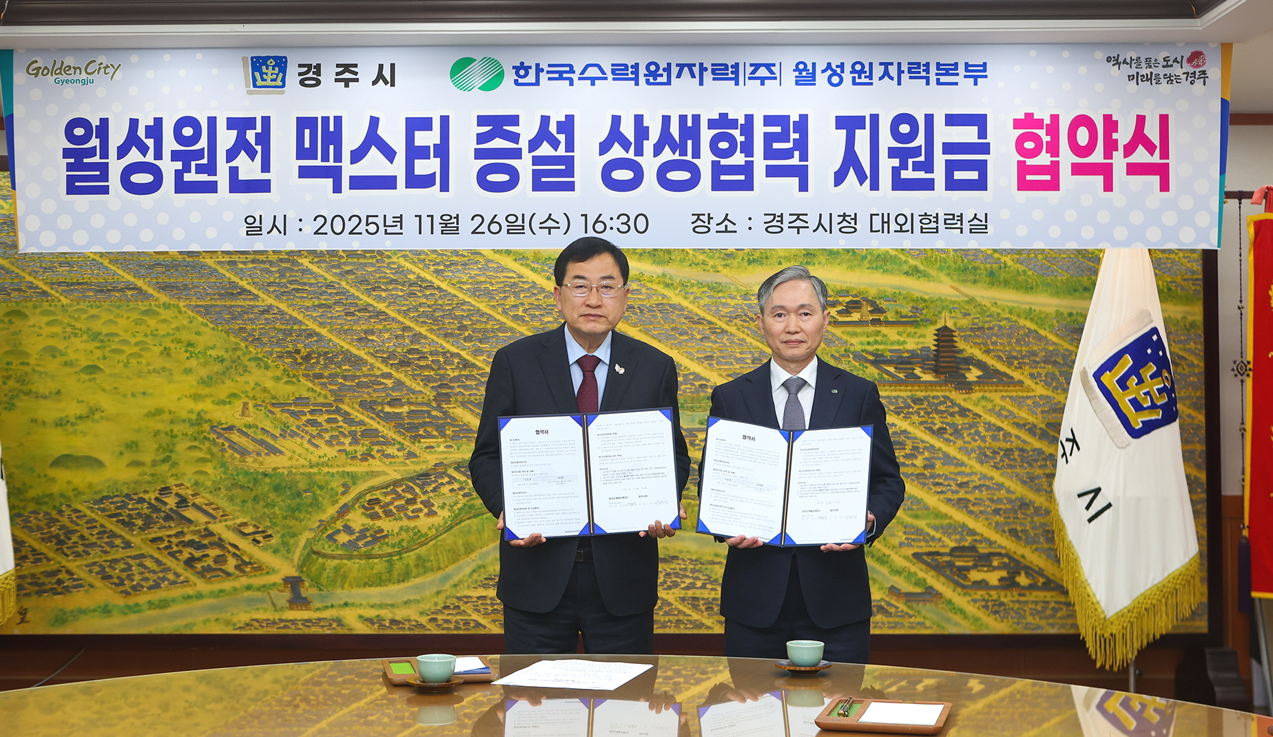 주낙영 경주시장(왼쪽)과 권원택 한국수력원자력 월성원자력본부장이 26일 경주시청 대외협력실에서 월성원전 맥스터 증설 상생협력 지원금 협약을 체결한 뒤 협약서를 들어 보이고 있다