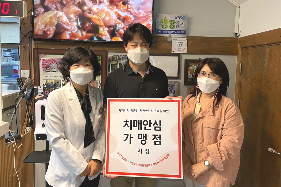 경주시 치매안심센터가 개인 사업장에 ‘치매안심가맹점’ 현판을 전달하며 기념촬영을 하고 있다