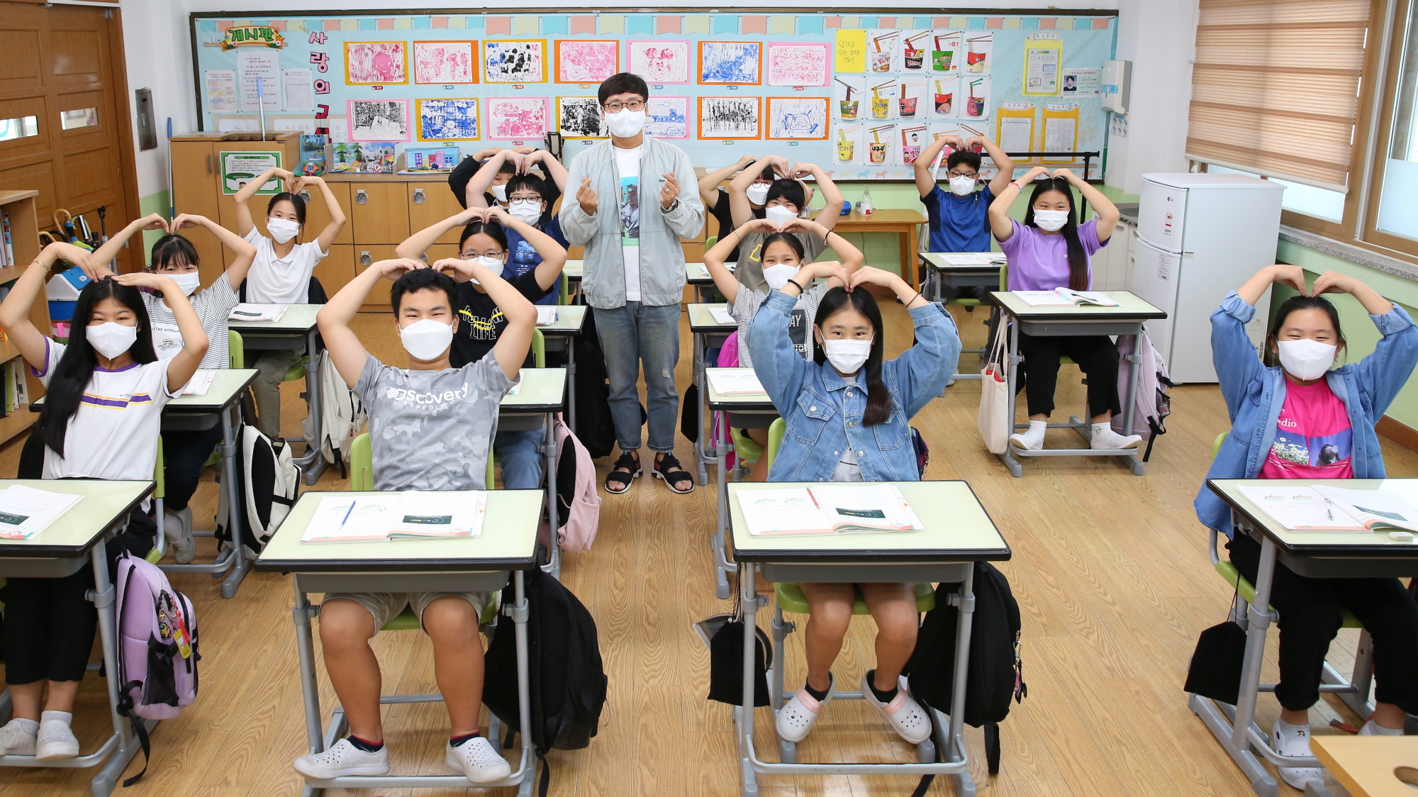 지난해 9월 경주시 사정동 소재 신라초등학교 학생들이 수업을 마친 직후 사랑의 하트를 만들어 보이고 있다