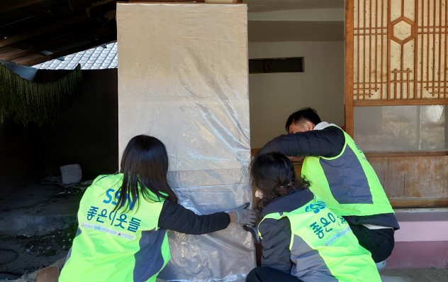 경주시 사회복지협의회 회원들이 지역의 한 취약계층을 방문해 비닐방풍막을 붙이고 있다.