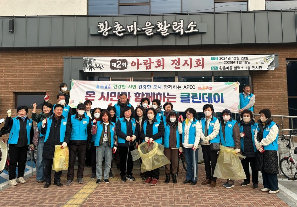 건강위원회 위원들이 APEC클린데이를 맞이해 마을 청소를 하고 있다.