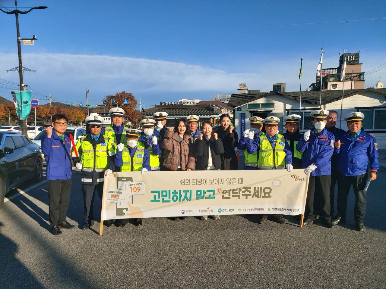 경주시정신건강복지센터 관계자들과 전국모범운전자연합회 경주지회 회원들이 11일 경주시외버스터미널 대로변에서 출근길 시민을 대상으로 자살예방 공동 캠페인을 진행하며 생명 존중 메시지가 담긴 현수막을 들고 기념 촬영을 하고 있다