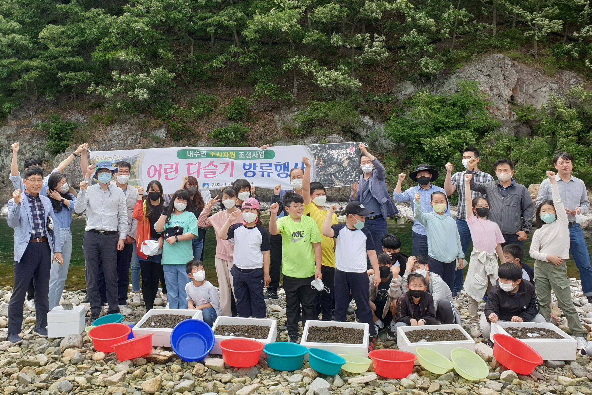 19일 경주시 산내면 자생단체 회원과 의곡초등학교 학생들이 산내면 동창천에서 어린 다슬기 방류 행사 전 기념촬영을 하고 있다