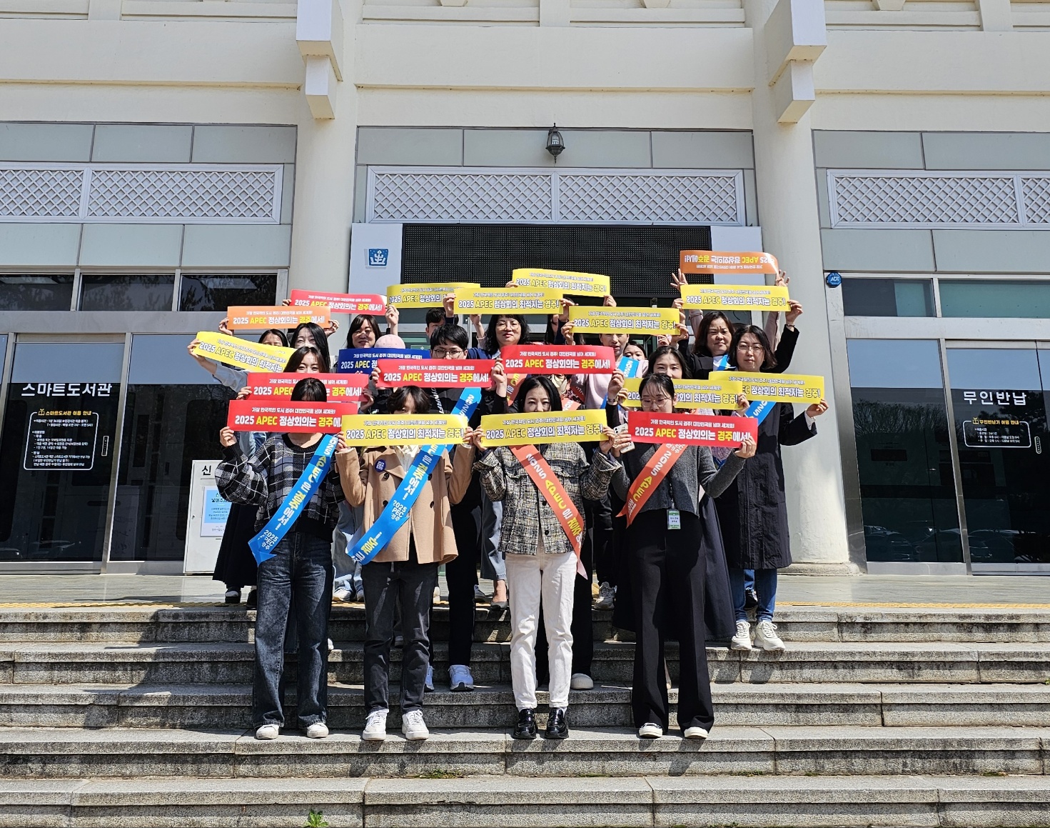 경주시립도서관 직원들이 지난 12일 제60회 도서관 주간 행사 중 APEC 정상회의 경주유치 응원 캠페인을 펼치고 있다.