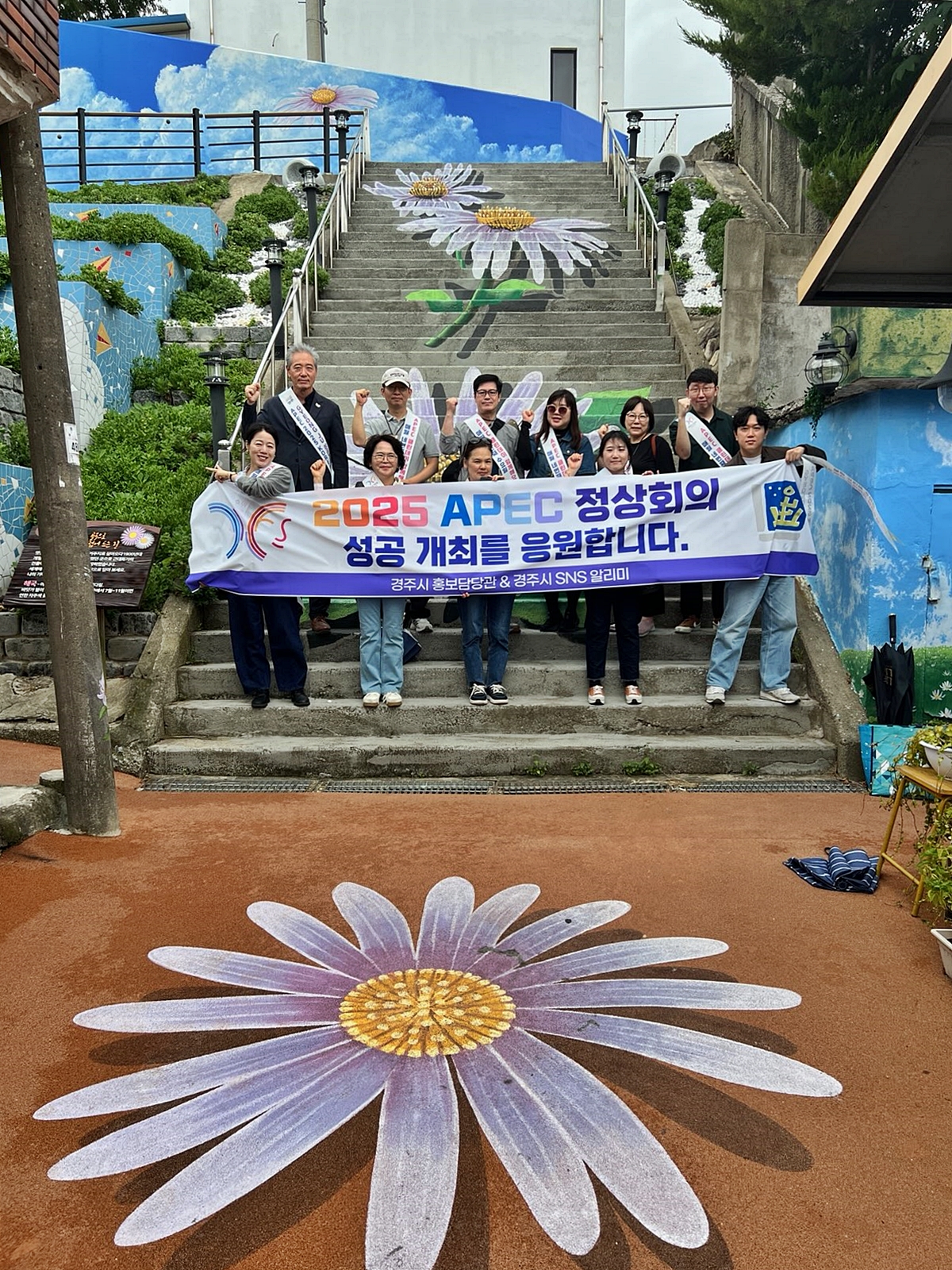 지난 11일 경주시 감포 해국길에서 열린 ‘SNS 알리미 팸투어 및 APEC 클린데이’ 참가자들이 2025 APEC 정상회의 성공 개최를 응원하며 기념촬영을 하고 있다.
