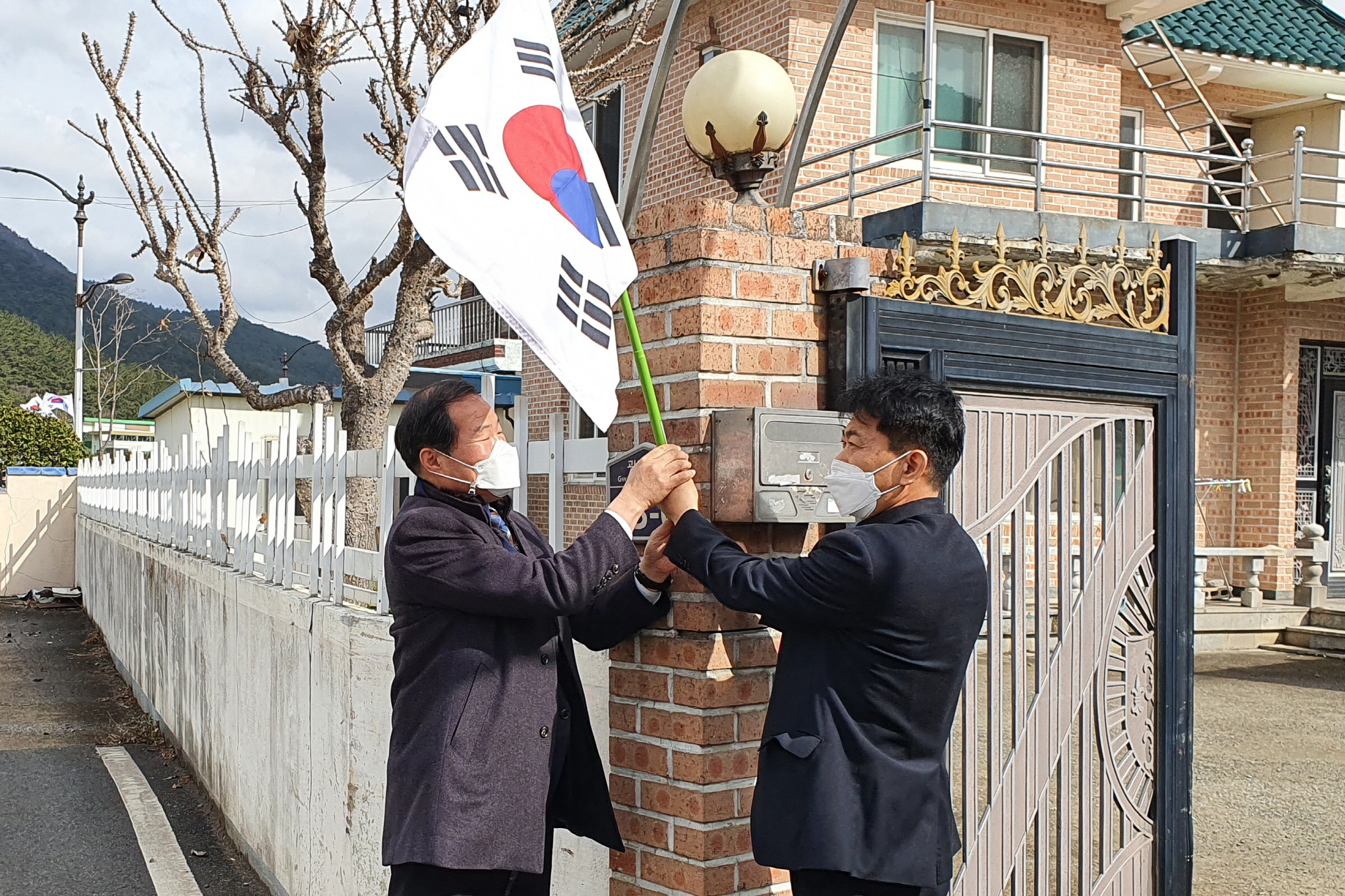 유남근 선도동장과 조병조 한국원자력환경공단 소통협력단장이 함께 태극기를 게양하는 모습
