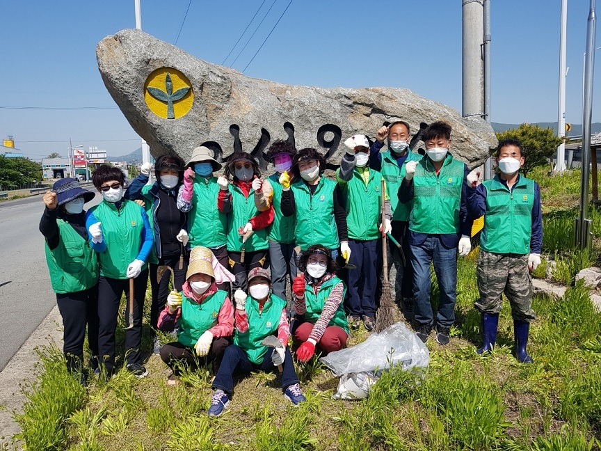 안강 새마을 동산 환경정비를 실시하는 모습과 함께 기념촬영을 하는 모습