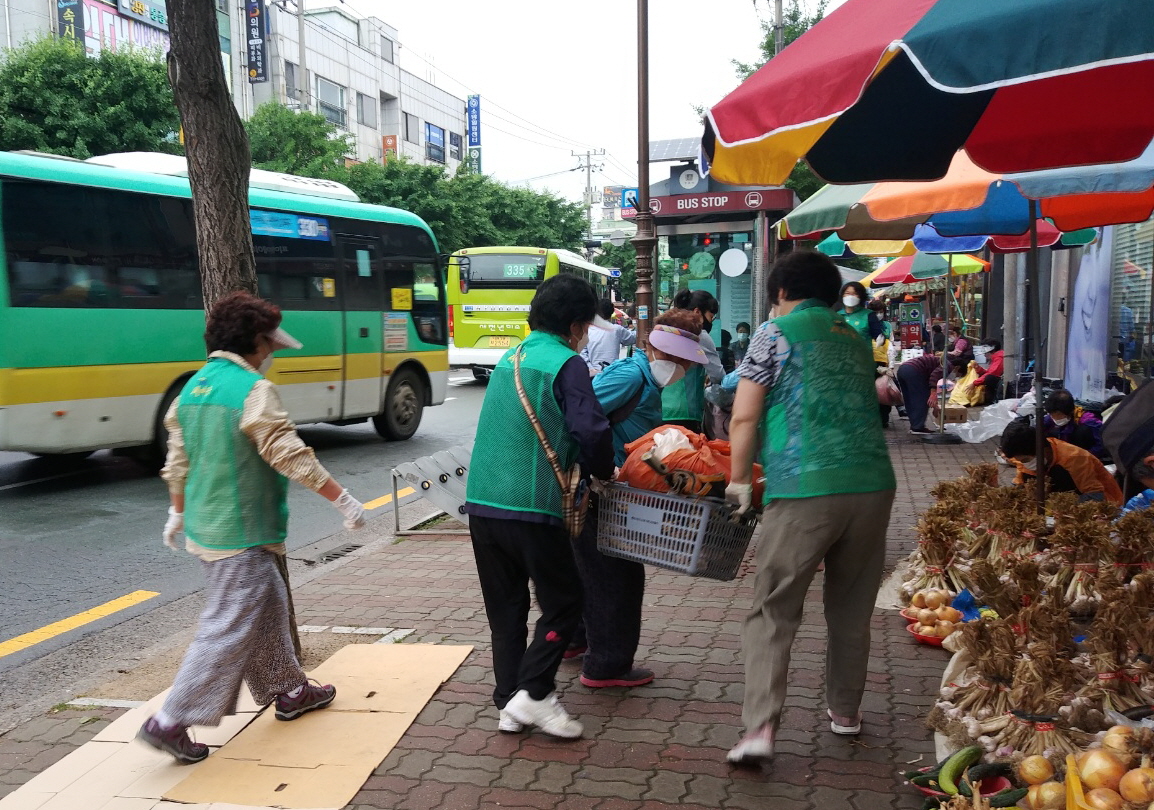 중부동 새마을부녀회 회원들이 중앙시장에서 어르신들의 짐을 들어드리는 모습