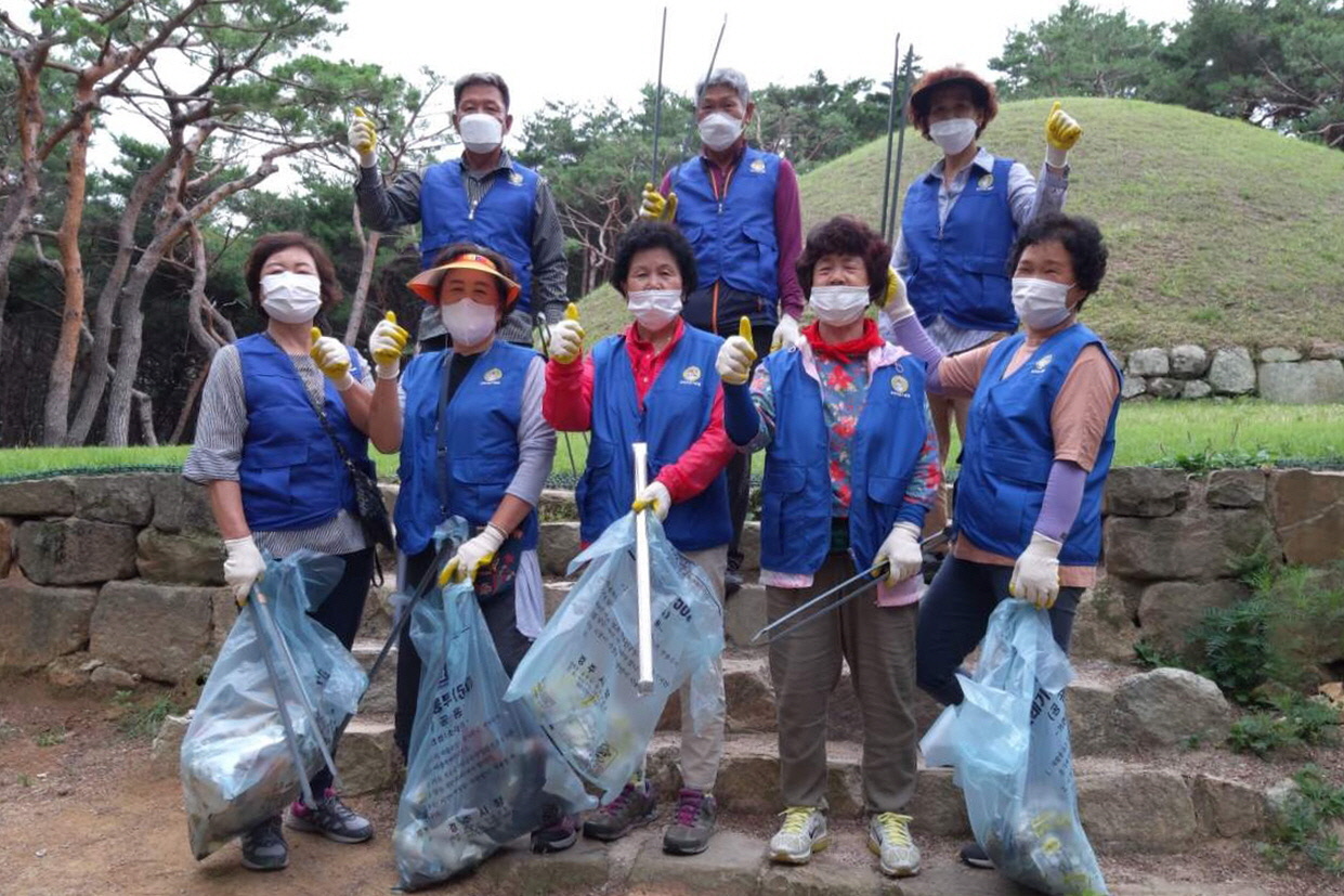 월성동 바르게살기위원회에서 선덕여왕릉 주변 환경정비에 나선 모습과 함께 단체사진 촬영을 하는 모습