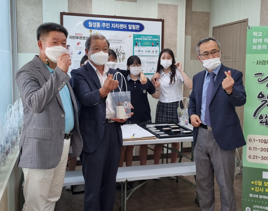 월성동에서 선덕여자중학교 관계자 및 학생들과 함께 보훈 나눔 행사를 가지며 함께 사진 촬영을 하는 모습