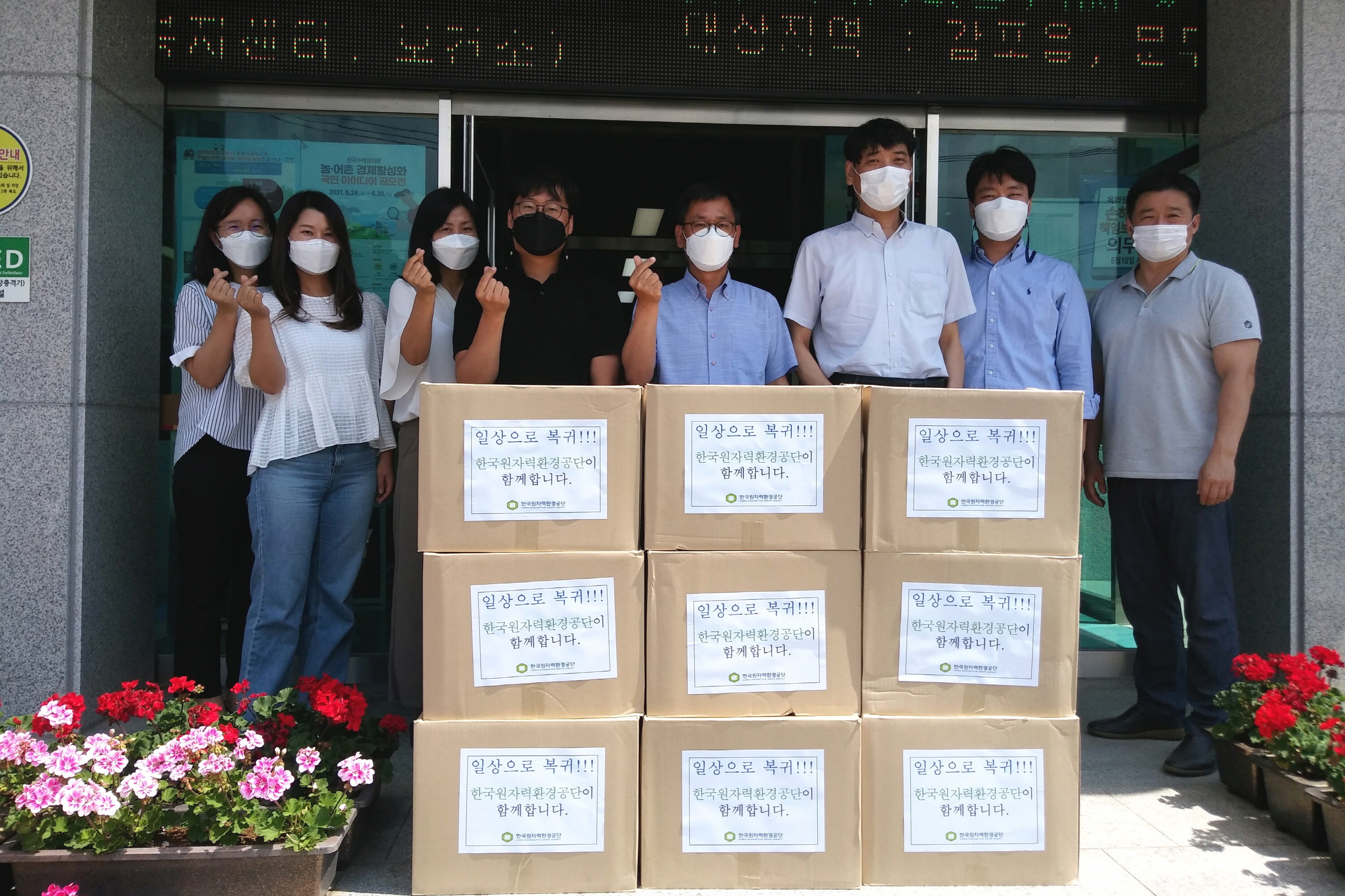 한국원자력환경공단에서 문무대왕면행정복지센터에 구호물품을 기탁하며 함께 단체 사진 촬영을 하는 모습