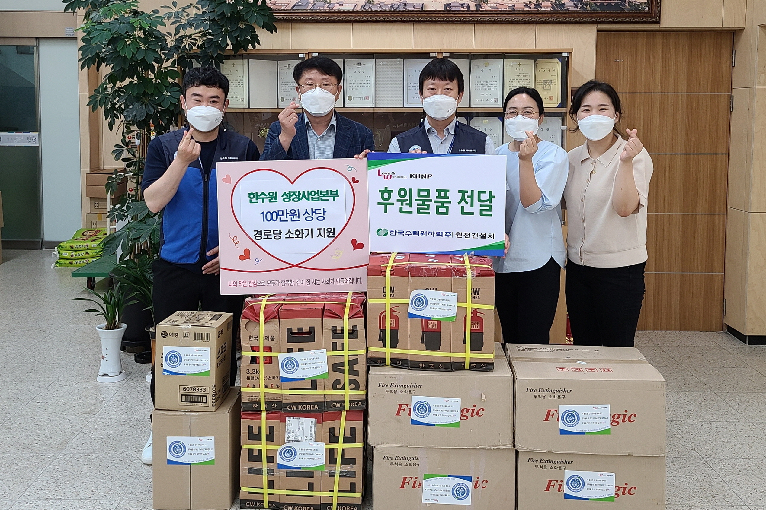 한수원 성장사업본부 봉사단에서 동천동 경로당을 위한 소화기를 기탁하며 함께 기념촬영을 하는 모습