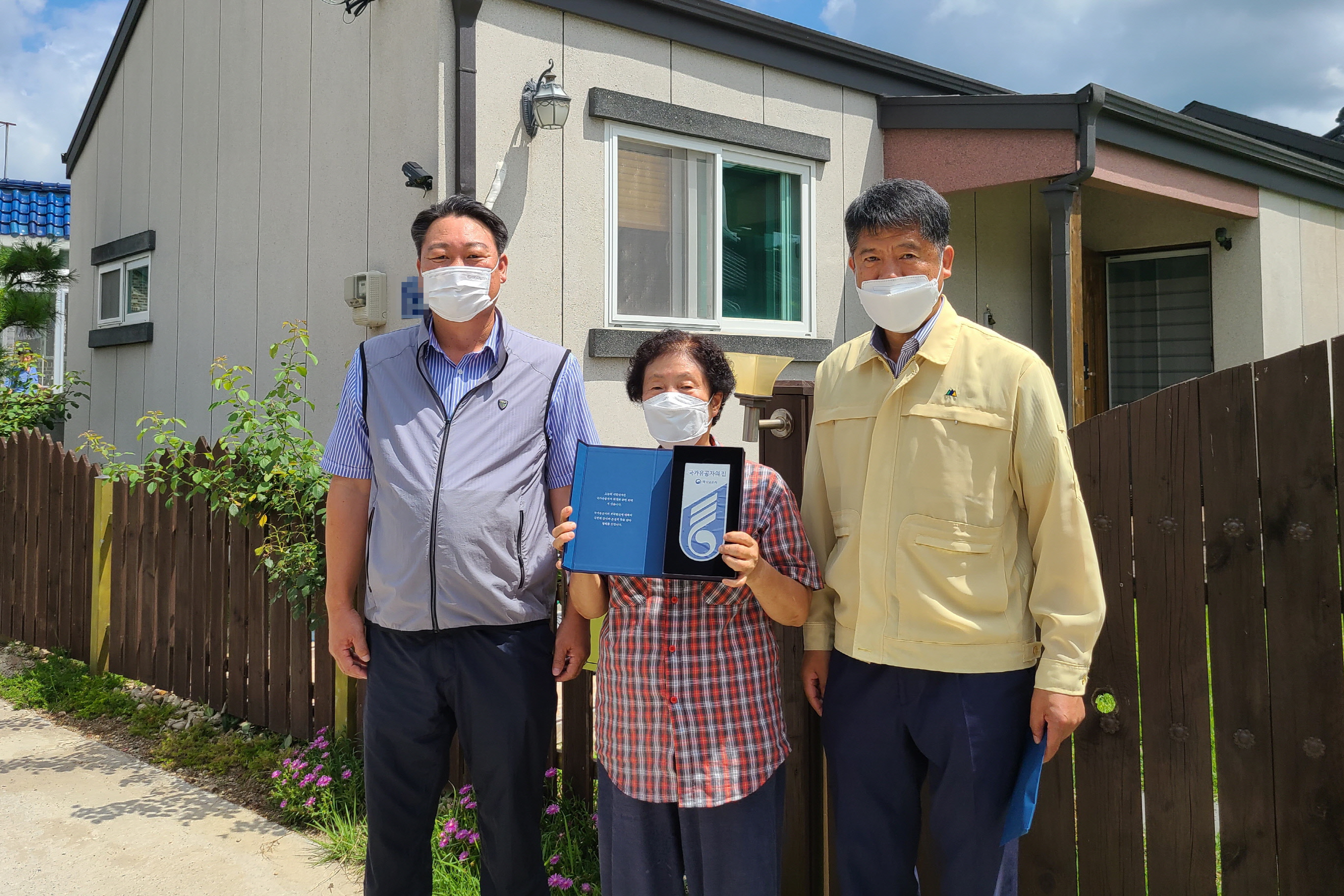 김재우 불국동장이 국가유공자 명패 달아드리기 사업 대상 가구를 방문해 명패를 전달한 후 사진 촬영을 하는 모습