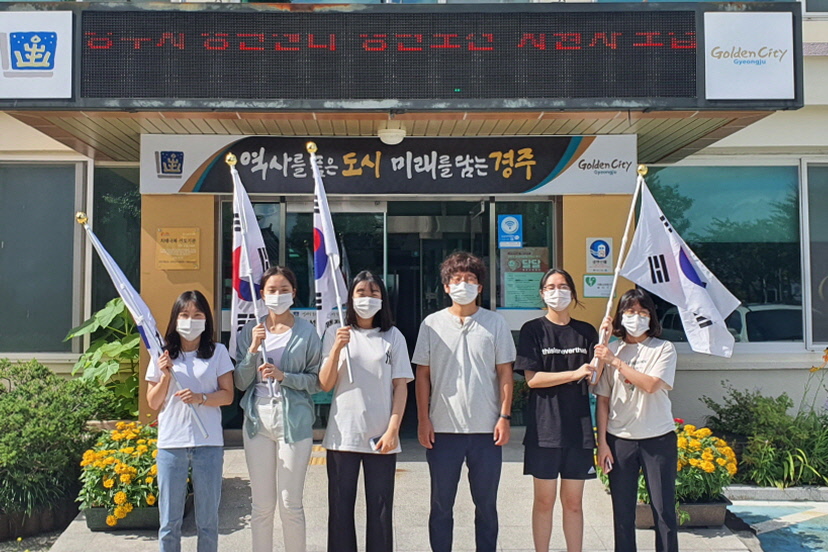 선덕여자중학교 학생들이 월성동 행정복지센터 앞에서 태극기 달기 행사를 펼치며 함께 사진 촬영을 하는 모습