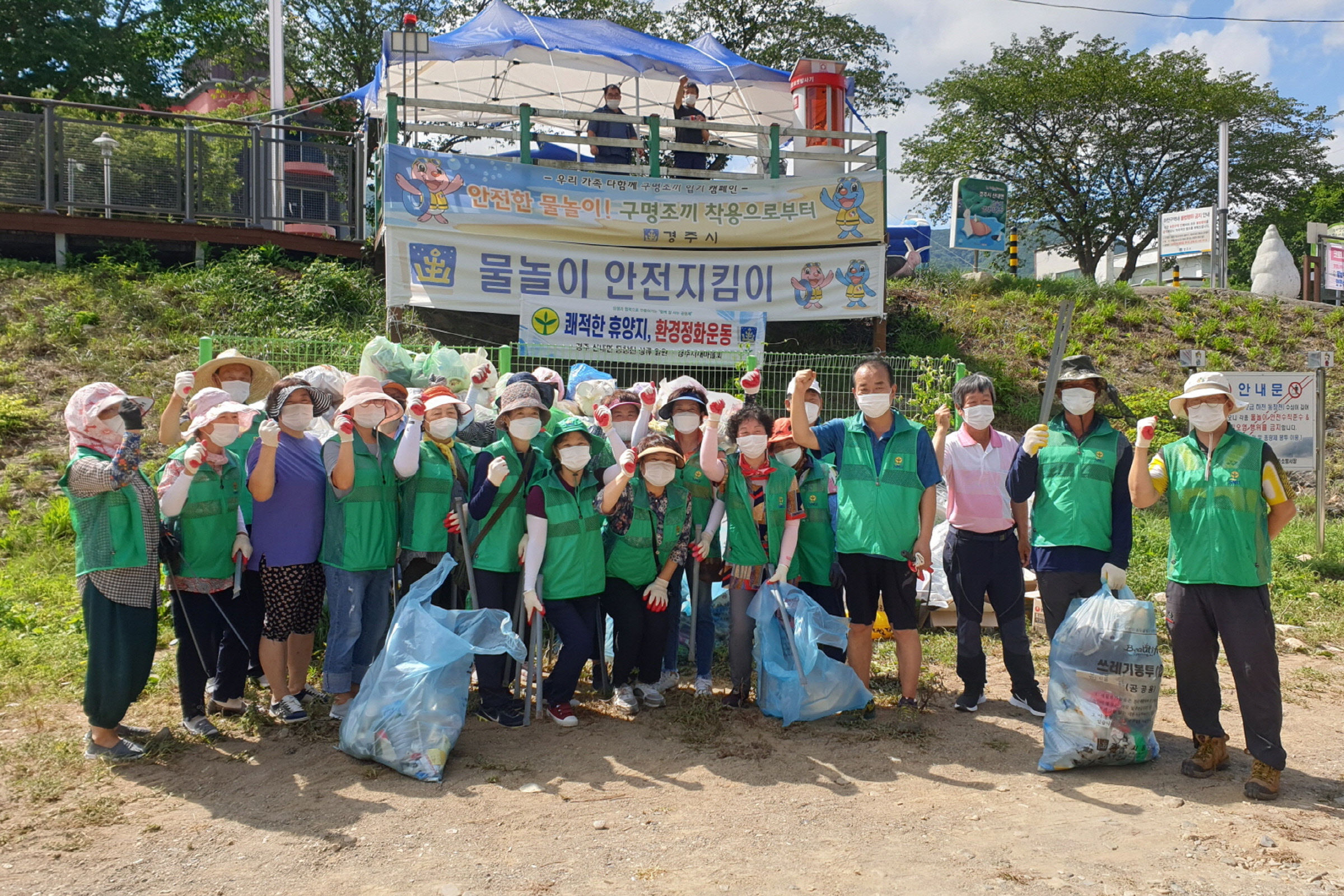 산내면 새마을지도자협의회·부녀회에서 동창천 청룡폭포 환경정화 운동을 전개한 후 함께 사진 촬영을 하는 모습