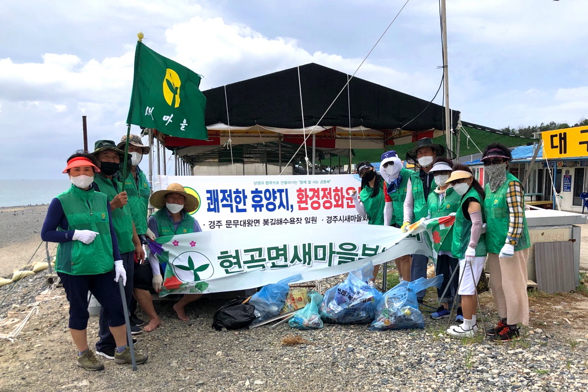 현곡면 새마을회에서 문무대왕면 봉길해수욕장을 찾아 환경정비를 실시하며 함께 사진 촬영을 하는 모습