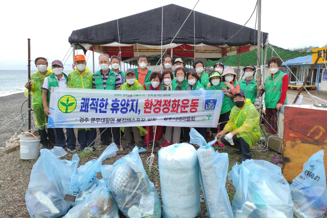 황남동 새마을회에서 새마을기 교체 및 봉길해수욕장 환경정비를 실시하는 모습과 함께 사진촬영을 하는 모습