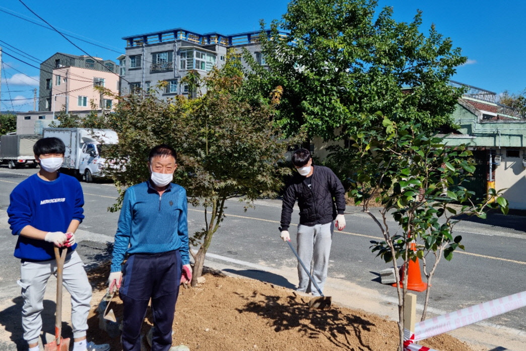 황성동에서 클린하우스 주변에 꽃과 나무를 식재하고, 조경석을 설치하는 모습