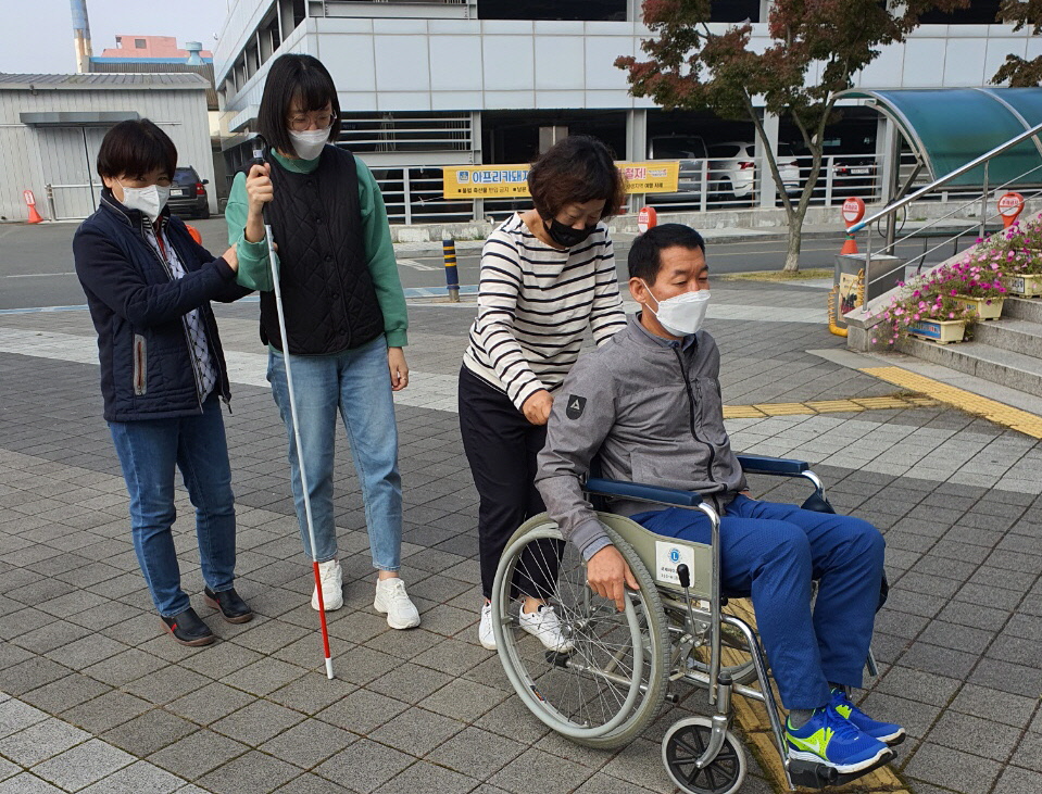 이상원 센터장과 직원들이 휠체어와 흰 지팡이를 이용해 장애인 보행체험을 실시하는 모습