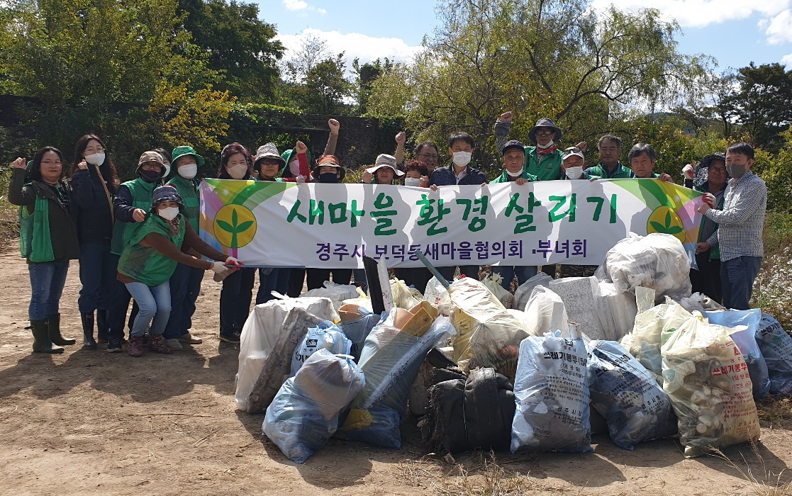 경주시 보덕동 새마을지도자협의회와 부녀회 회원들이 13일 덕동댐 일대에서 환경정비 활동을 한 후 기념촬영을 하고 있다.