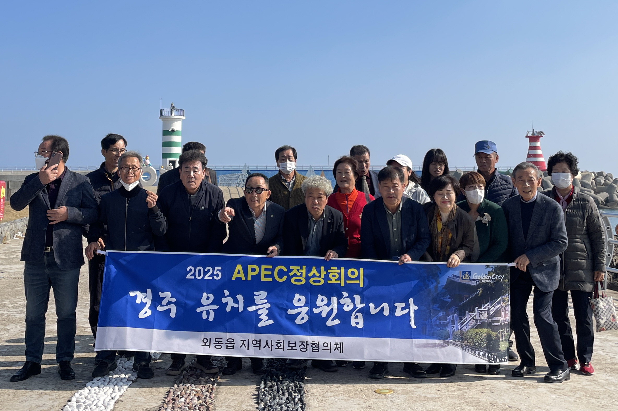 16일 경주시 외동읍지역사회보장협의체 위원들이 경주 감포 읍천항에서 2025 APEC정상회의 경주 유치 지지하며, 기념촬영을 하고 있다.