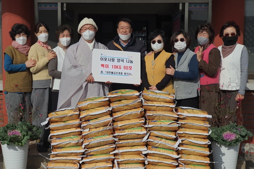 24일 원각사 앞마당에서 민원복지과장 이채두와 기부자 성광스님이 전달식 기념촬영을 하고 있다