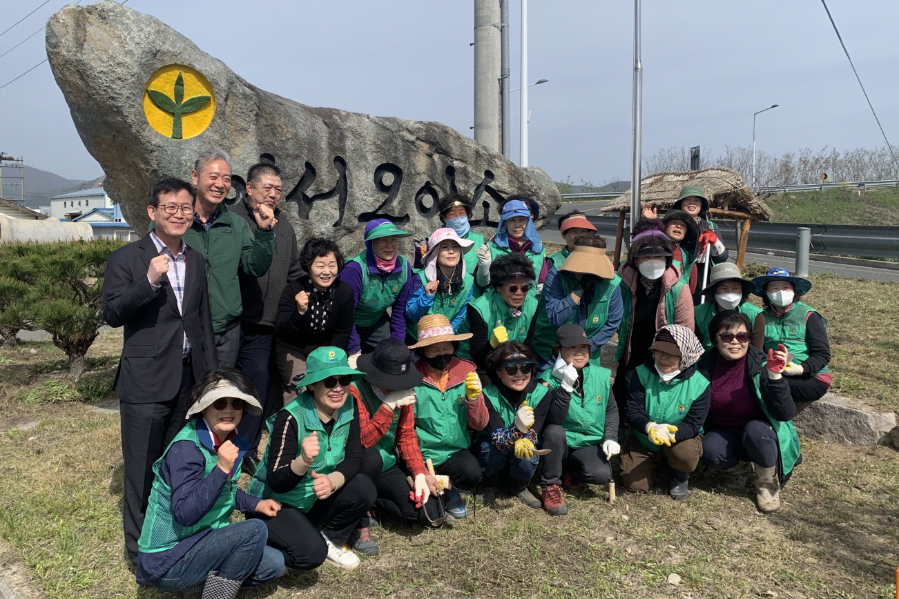 1-1. 경주시 안강읍 새마을부녀회 회원들이 10일 안강IC 입구 새마을동산 일대에서 봄맞이 환경정비를 진행하기 전에 기념촬영을 하고 있다.jpg